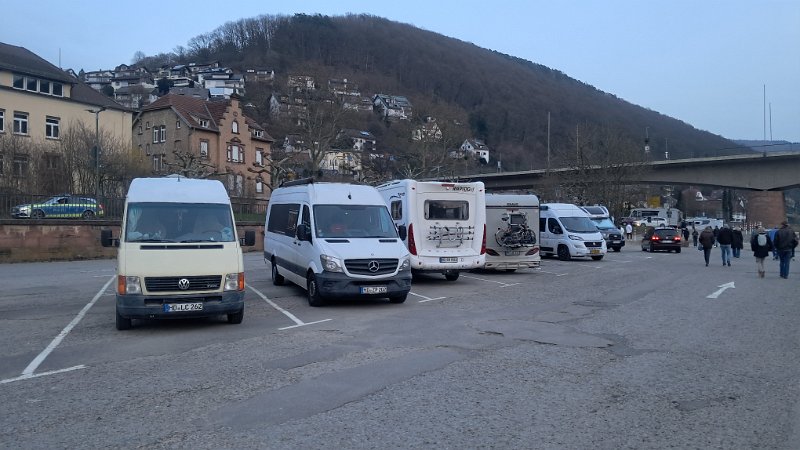 20260306_180730.jpg - Hinter uns verläuft eine stark befahrene Bundesstraße und die Parzellen sind eng und auf Asphalt.